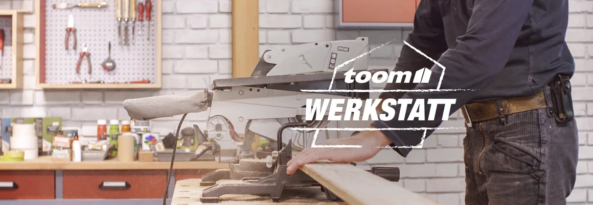 Toom Werkstatt-Logo mit verschwommenem Hintergrund, auf dem eine Person Holz mit einer Kappsäge sägt